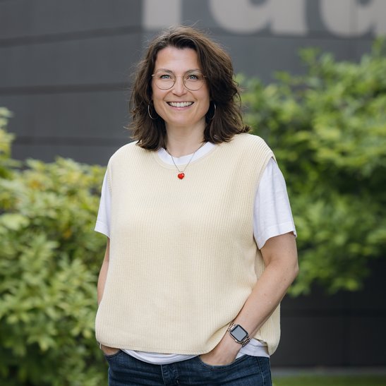Eine Frau mit Brille und beigem Pulli
